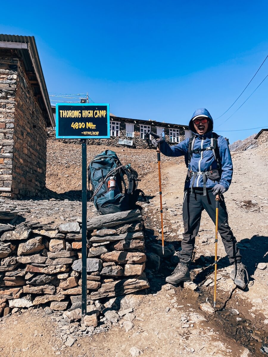 Pati steht endlich neben dem Schild des Highcamps vom Thorong La Pass